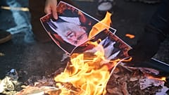 Protesters burn pictures of Iranian Ayatollah Ali Khamenei as they march in support of regime change in Iran during a protest in Toronto, 1 February 2026