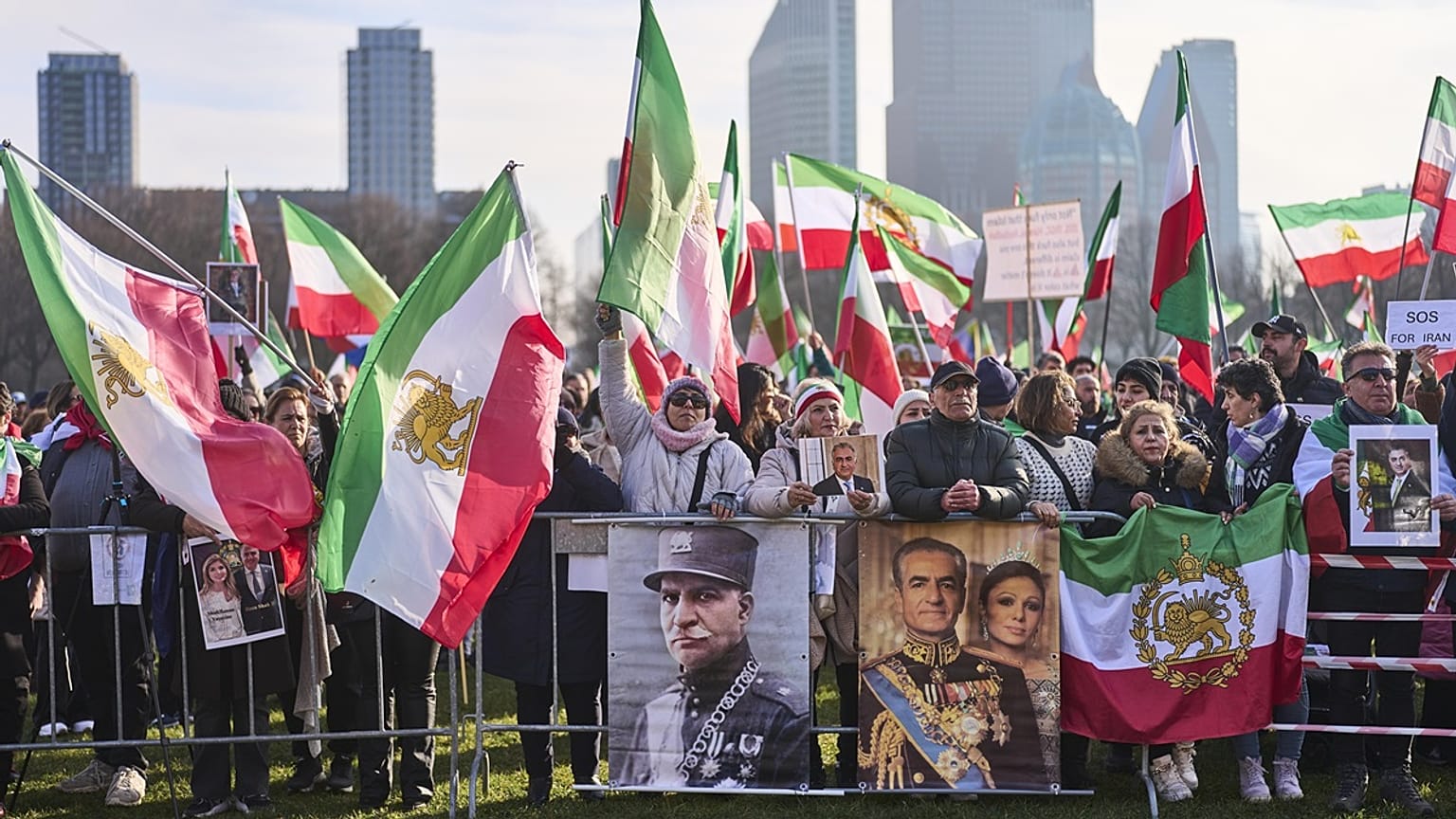 Manfiestantes ondean banderas iraníes.