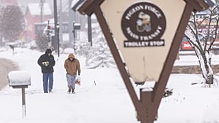 رجلان يسيران عبر الثلوج على الطريق السريع يوم السبت 31 يناير 2026 في بيجن فورج، تينيسي، خلال عاصفة شتوية. (تصوير: أسوشيتد برس/ويد باين)