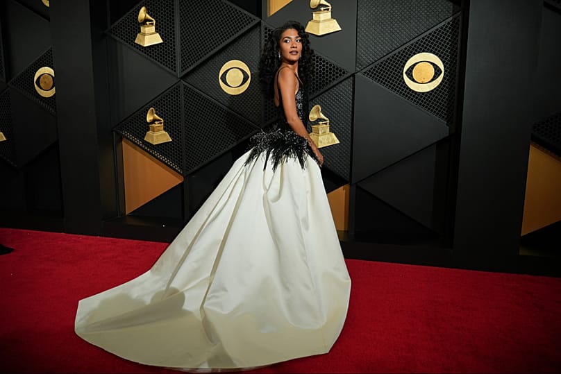 Olivia Dean bei den Grammys 2026 im schwarz-weißen Kleid mit Federn.