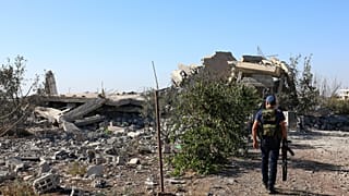 يسير مسلح بجوار أنقاض منزل دُمر خلال الاشتباكات الطائفية الأخيرة في بلدة السويداء ذات الأغلبية الدرزية، جنوب سوريا، في 19 سبتمبر 2025. (صورة من وكالة أسوشيتد برس/فهد كيوان)