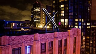 Workers install lighting on an "X" sign atop the company headquarters, formerly known as Twitter, in downtown San Francisco, July 28, 2023.