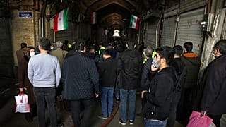 تجمع الناس بالقرب من موقع حريق في البازار الكبير بطهران، إيران، يوم السبت 12 فبراير/شباط 2022.