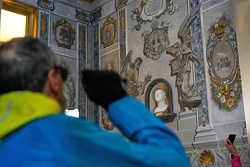 Varias personas toman fotografías en un fresco restaurado en memoria del difunto rey Umberto II de Italia que representa ángeles en el interior de la Basílica de San Lorenzo en Lucina, Roma, 1 de febrero de 2026.
