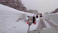 Vehicles move through snow