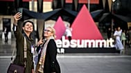 Two attendees pose outside Web Summit Qatar.