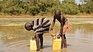 ARCHIVES - Sur cette photo du 4 novembre 2010, des enfants puisent de l'eau potable dans un étang à l'aide de filtres fournis par le Carter Center au Soudan du Sud.