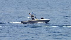 ФАЙЛ: Корабль иранской революционной гвардии наблюдает за американским военным кораблем в Ормузском проливе, 19 мая 2023 года.