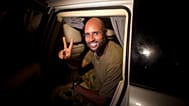 FILE - In this Tuesday, Aug. 23, 2011 file photo, Moammar Gadhafi's son Seif al-Islam makes a victory sign as he appears at the Rixos hotel in Tripoli, Libya