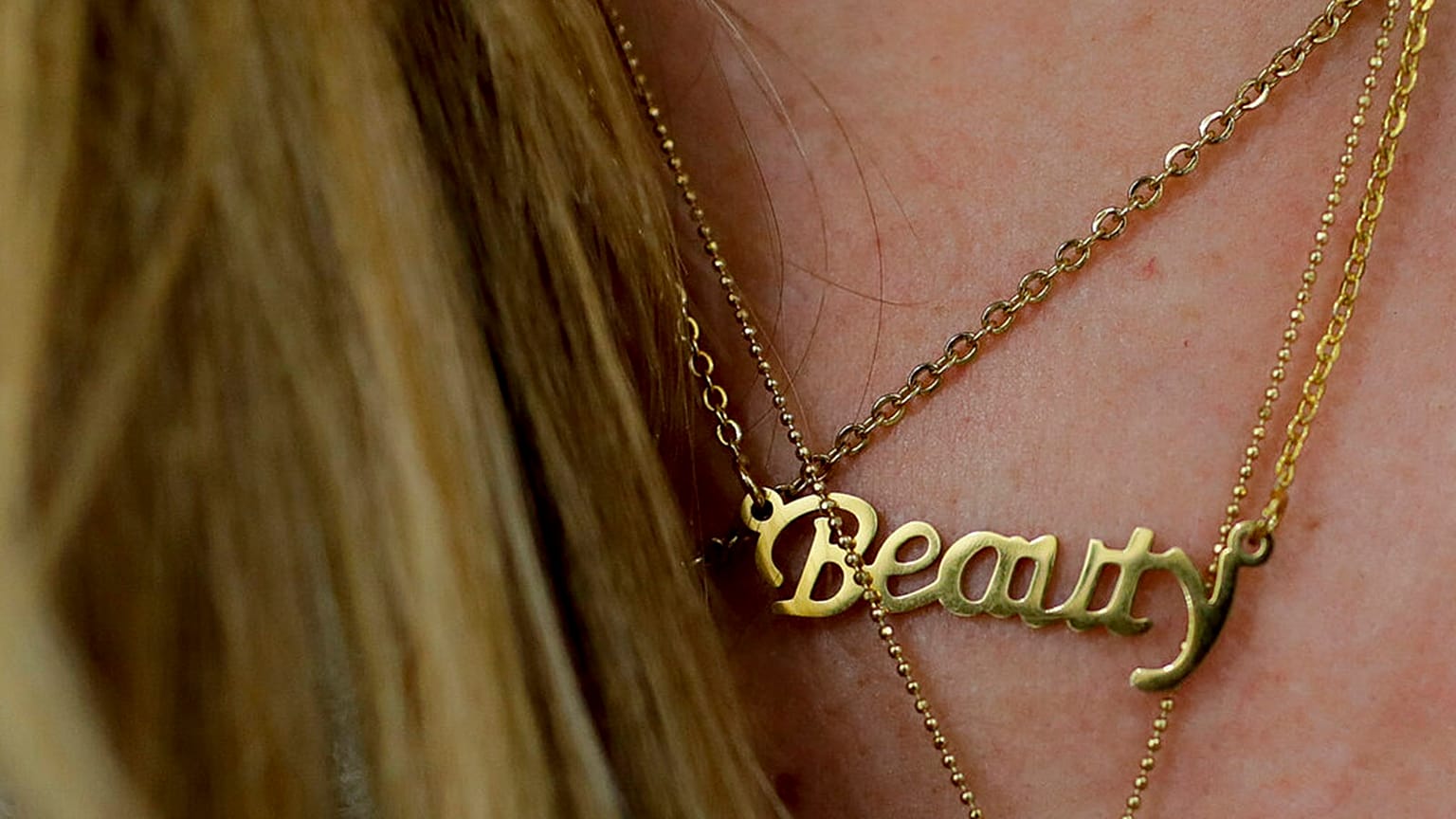FILE: A woman wears a necklace featuring the word "Beauty" at a beauty salon, 4 April 2019, illustration