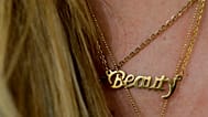 FILE: A woman wears a necklace featuring the word "Beauty" at a beauty salon, 4 April 2019, illustration