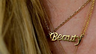 FILE: A woman wears a necklace featuring the word "Beauty" at a beauty salon, 4 April 2019, illustration