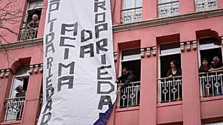 A banner with the words "solidarity above property" is unfurled from a residential building, during a demonstration to demand solutions for Portugal's housing crisis, 2023. 