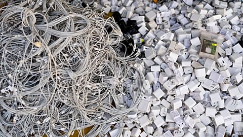 FILE -Used charging cables and power adapters are piled up at a shop in Nhat Tao market, the largest informal recycling market in Ho Chi Minh City, Vietnam, Jan. 28, 2024. 