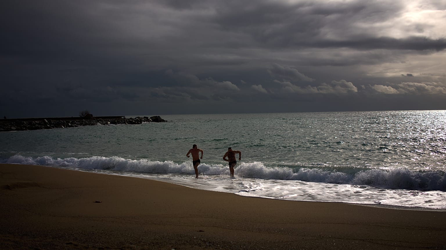 Dos personas se meten al mar en Barcelona con la borrasca Leonardo azotando España