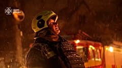 Ein Feuerwehrmann arbeitet am Einsatzort bei dichtem Schneetreiben.