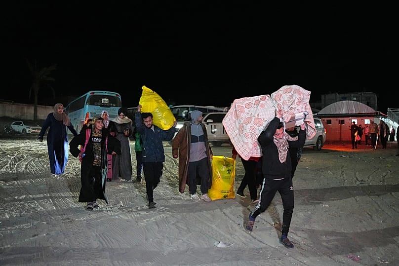 Palestinians carry the belongings of relatives arriving in Gaza from Egypt following the long-awaited reopening of the Rafah border crossing, in Khan Younis, Feb. 5, 2026.