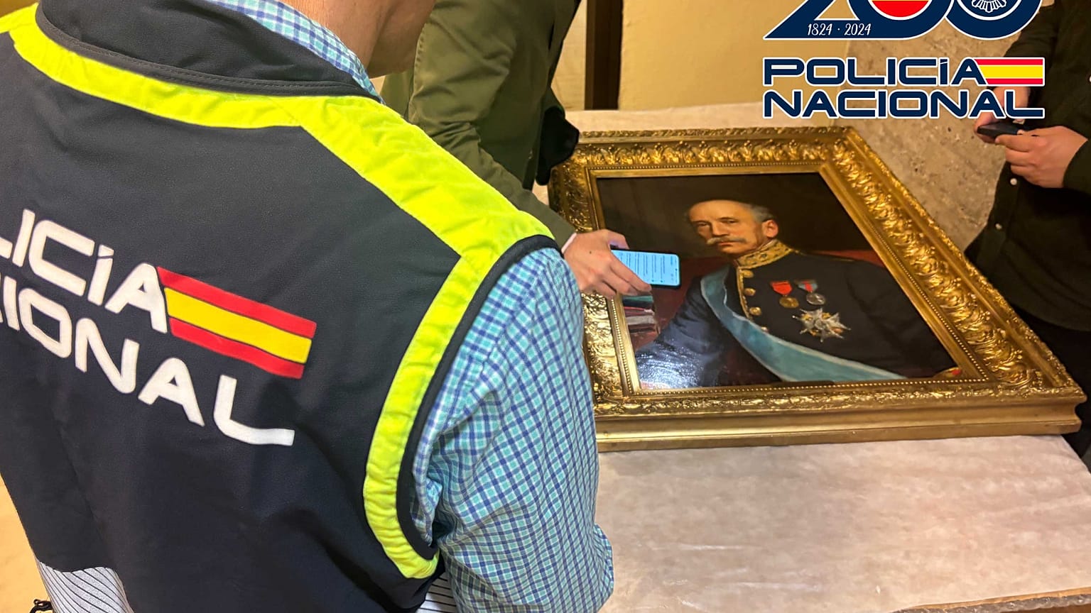 Las autoridades inspeccionan uno de los cuadros recuperados.