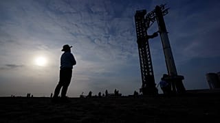 FILE - Visitors look on as SpaceX's Starship, the world's biggest and most powerful rocket, stands ready for a scheduled launch from Starbase in Boca Chica, Texas, 