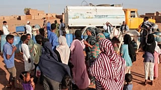 أشخاص يملأون المياه في نقطة توزيع مجانية بسبب انقطاع المياه في الخرطوم، السودان، الجمعة 30 يناير 2026. 