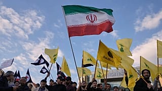 أعلام لحزب الله يتوسطها علم لإيران