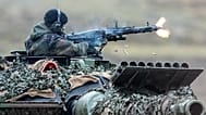 Title: Germany Ukraine Arms Industry. A soldier fires a machine gun from a Leopard 2 tank.