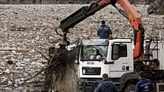 In Višegrad räumen Arbeiter mit einem Kran Müll aus der verstopften Drina.
