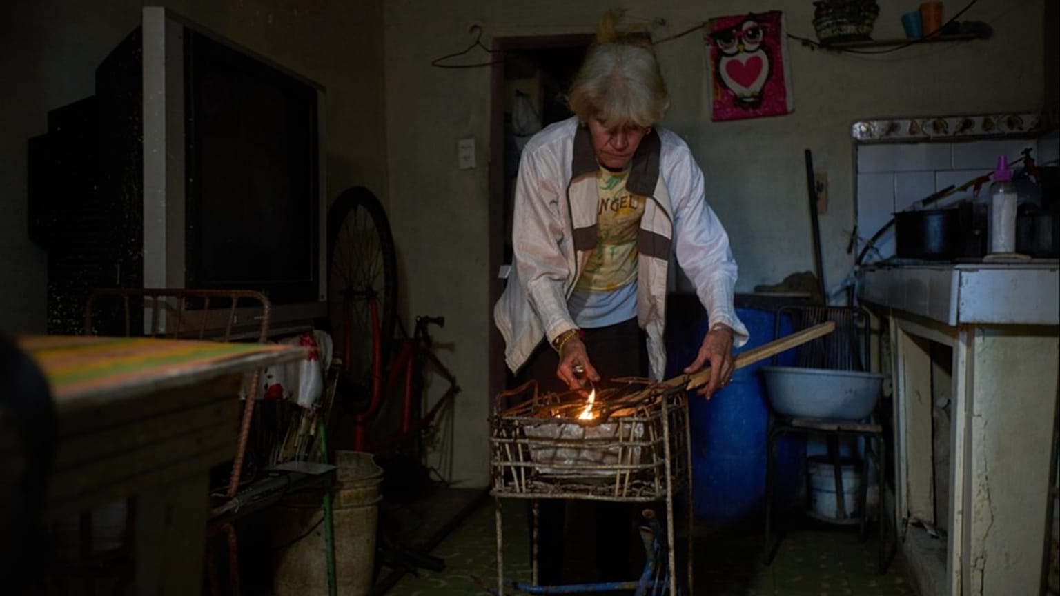 Cuban woman lights coals to cook dinner during a scheduled blackout to ration energy in Santa Cruz del Norte, Tuesday, Feb. 3, 2026