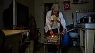 Cuban woman lights coals to cook dinner during a scheduled blackout to ration energy in Santa Cruz del Norte, Tuesday, Feb. 3, 2026