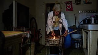 Cuban woman lights coals to cook dinner during a scheduled blackout to ration energy in Santa Cruz del Norte, Tuesday, Feb. 3, 2026