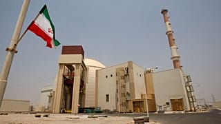 An Iranian flag flutters in front of the reactor building of the Bushehr nuclear power plant, just outside the southern city of Bushehr, Iran, Aug. 21, 2010. 
