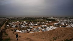 طفل يمرّ بجوار خيام تؤوي فلسطينيين نازحين في دير البلح، وسط قطاع غزة، الأحد 1 فبراير/شباط 2026. (تصوير: عبد الكريم هنا / أسوشييتد برس)