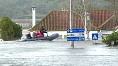 Ein Rettungsteam fährt mit einem Boot durch das völlig überflutete Stadtzentrum.