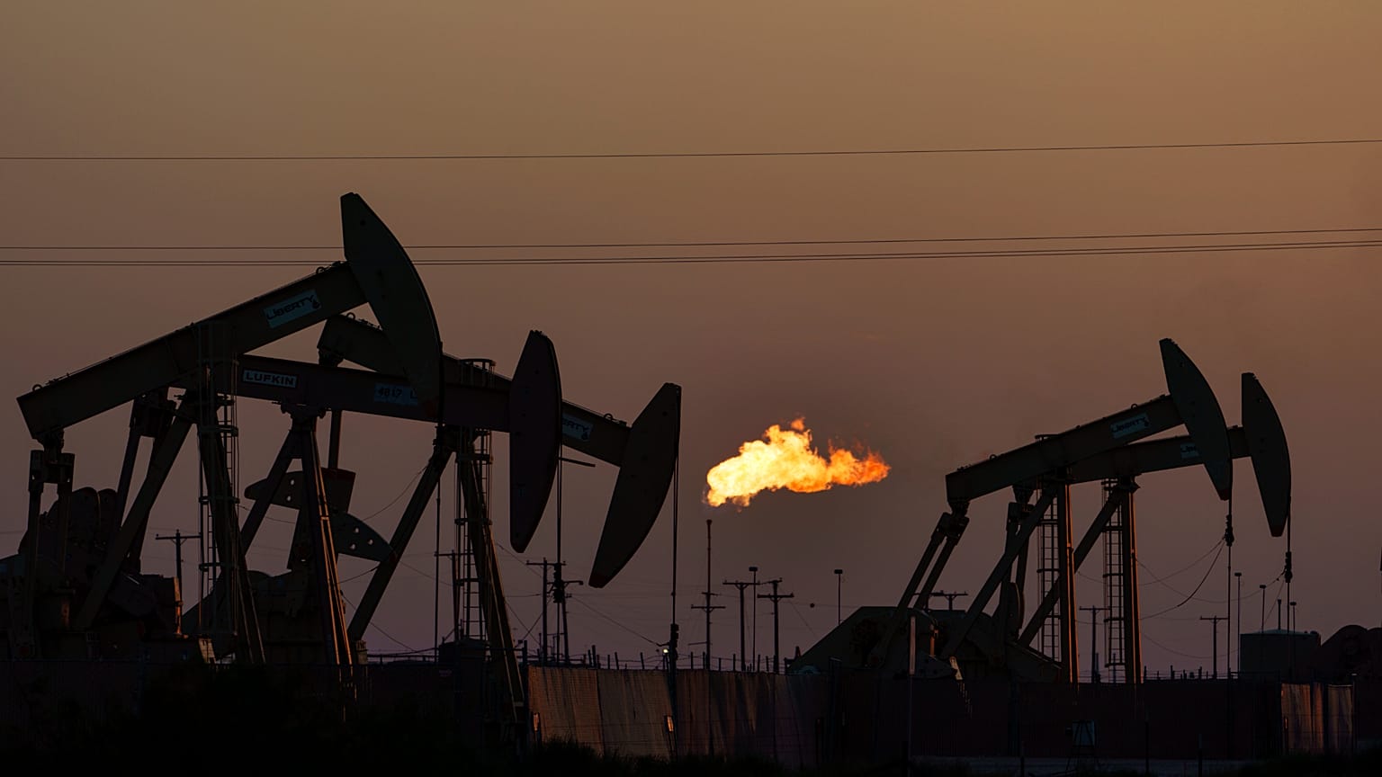A flare burns off methane and other hydrocarbons as oil pumpjacks operate in the Permian Basin in Midland, Texas, Oct, 2021. 