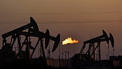 A flare burns off methane and other hydrocarbons as oil pumpjacks operate in the Permian Basin in Midland, Texas, Oct, 2021. 