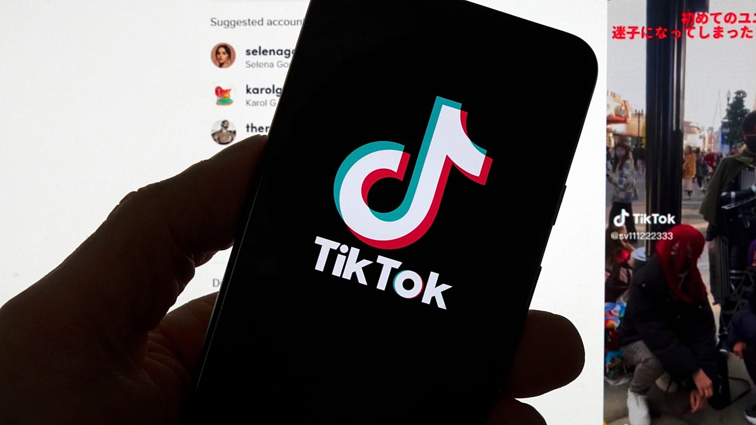 FILE - The TikTok logo is seen on a mobile phone in front of a computer screen which displays the TikTok home screen, Saturday, March 18, 2023, in Boston