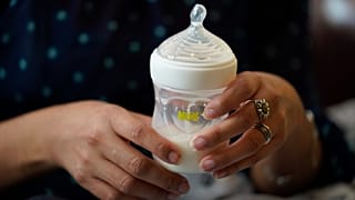 FILE: Olivia Godden holds a bottle of baby formula as she feeds her infant son.