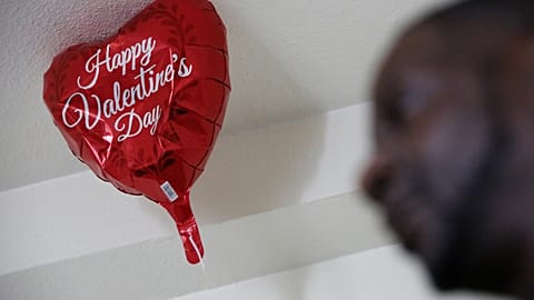 A 'Happy Valentine's Day' balloon floats over Vernon Mandigo in a Franciscan Towers flat.