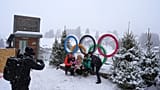 Persone scattano foto con il logo olimpico in vista dei Giochi olimpici invernali Milano Cortina 2026, a Cortina d'Ampezzo, in Italia.