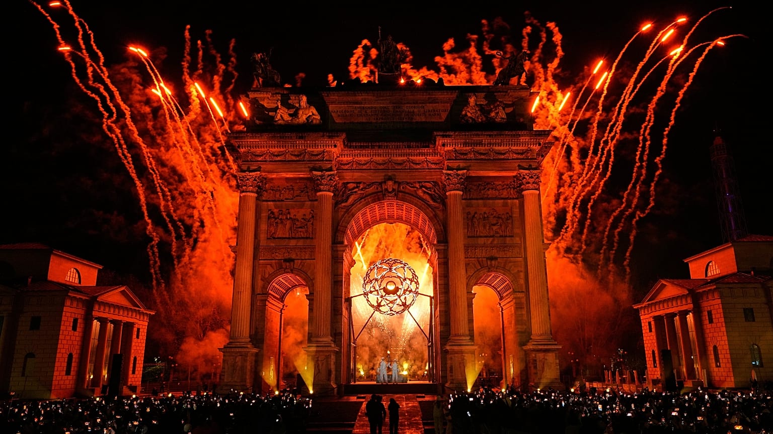 L'ex sciatrice italiana Deborah Compagnoni e l'ex sciatore italiano Alberto Tomba accendono il braciere all'Arco della Pace durante la cerimonia di apertura olimpica 