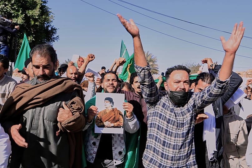  ليبيون يسيرون لحضور جنازة سيف الإسلام، نجل الزعيم الليبي الراحل معمر القذافي، حاملين صورة والده في مدينة بني وليد، ليبيا، الجمعة 6 فبراير/شباط 2026. 