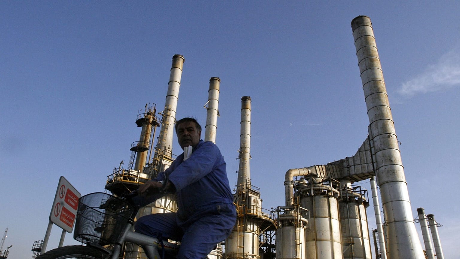 رجل يشق طريقه على دراجة في مصفاة النفط في طهران, إيران,يوم السبت, نوفمبر. 17, 2007