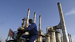 رجل يشق طريقه على دراجة في مصفاة النفط في طهران, إيران,يوم السبت, نوفمبر. 17, 2007