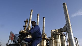 رجل يشق طريقه على دراجة في مصفاة النفط في طهران, إيران,يوم السبت, نوفمبر. 17, 2007