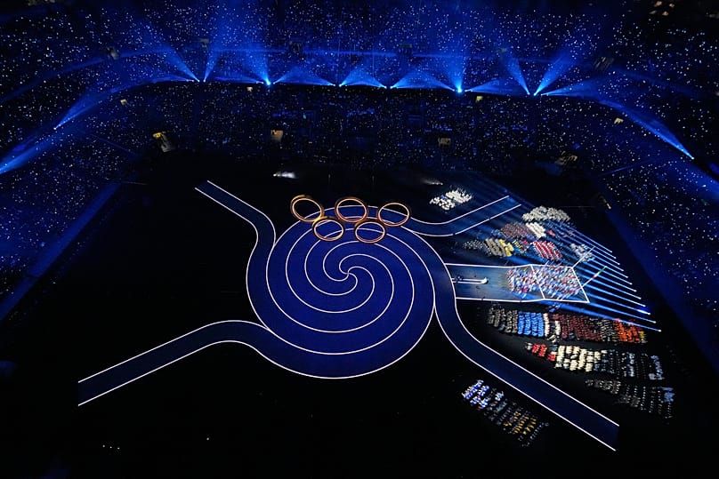 Des athlètes regardent la cérémonie d'ouverture des Jeux olympiques d'hiver de 2026, à Milan.