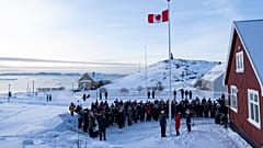 Außenministerin Anita Anand hisst im Bildvordergrund am Freitag, dem sechsten Februar 2026, die kanadische Flagge am neuen Konsulat in Nuuk, Grönland.