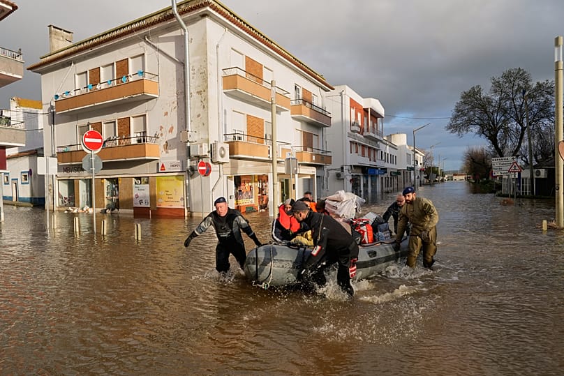 Les résidents d'un hôtel évacués sur un pneumatique le long d'une rue inondée à Alcácer do Sal, sud du Portugal, vendredi 6 février 2026. (AP Photo/Ana Brigida)