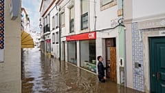 Moradores colocam tábuas para impedir que a água entre nas casas inundadas após o rio Sado transbordar devido às fortes chuvas em Alcácer do Sal, sul de Portugal, na sexta-fei