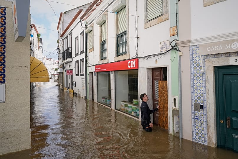 Residents place planks to prevent water from entering flooded homes after the Sado River overflowed due to heavy rains in Alcácer do Sal, southern Portugal, February 6, 2026.