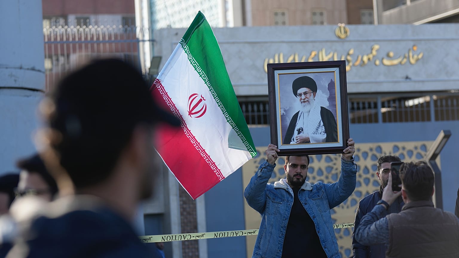رجل عراقي يحمل صورة للمرشد الأعلى الإيراني آية الله علي خامنئي أمام السفارة الإيرانية، خلال تجمع لإظهار التضامن مع إيران ومعارضة التهديدات الأمريكية بشن ضربة عسكرية، في بغداد،